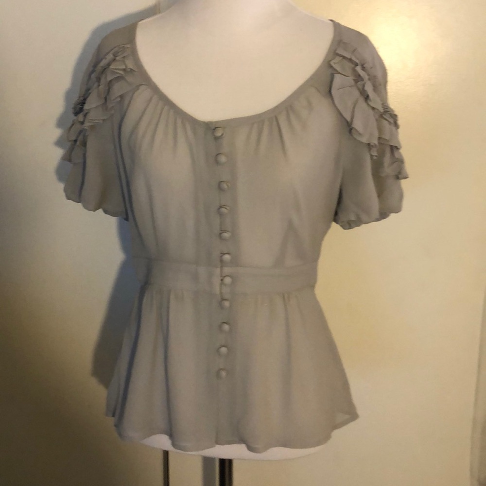 A grey blouse fitted on the waist